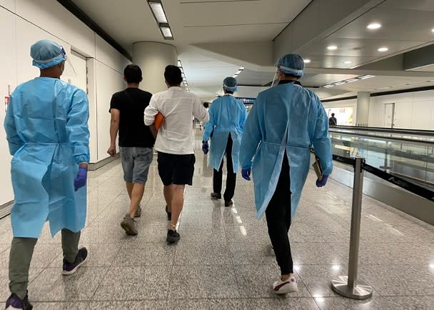 Immigration officers put on protective equipment to assist Hong Kong people seeking help to go to the dedicated immigration counter.