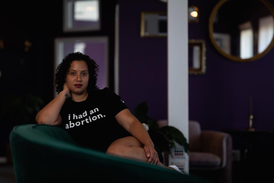 A woman is seen reclining on a green couch.