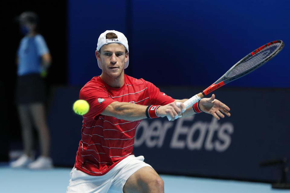 El argentino Diego Schwartzman devuelve frente a Novak Djokovic durante la segunda jornada de la Copa Masters de la ATP, el lunes 16 de noviembre de 2020, en la arena 02 de Londres. (AP Foto/Frank Augstein)