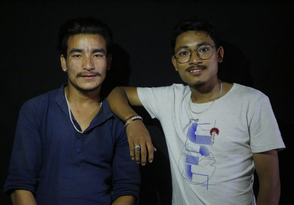 In this Sept. 25, 2018, photo, Rakesh Twanabasu, 24, web designer, right and Saroj Dhaubanjar, 23, delivery man pose for photographs without the mask of god Khyak in Kathmandu, Nepal. For centuries, Nepal has celebrated the Indra Jatra festival of masked dancers, which officially begins the month-long festivities in the Hindu-dominated Himalyan nation. The dancers, who come from a variety of backgrounds, pull off this performance every year despite minimal financial support from the government and other sources, they say. (AP Photo/Niranjan Shrestha)