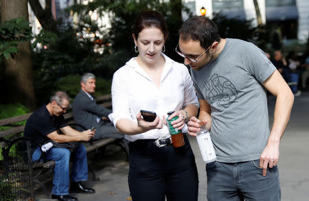 Alexandra Dalton and Sam Rosen look at her cellphone as she received a text alert that the Trump administration sent all U.S. cellphones to test a previously unused alert system that aims to warn the public about national emergencies at Madison Square Park in Manhattan, New York, U.S., October 3, 2018. REUTERS/Shannon Stapleton