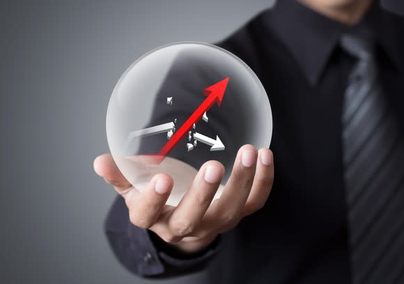 A man holding a crystal ball with a rising arrow inside it