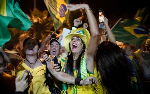Supporters of Jair Bolsonaro celebrate in front of his residence in Rio de Janeiro - Credit: AP