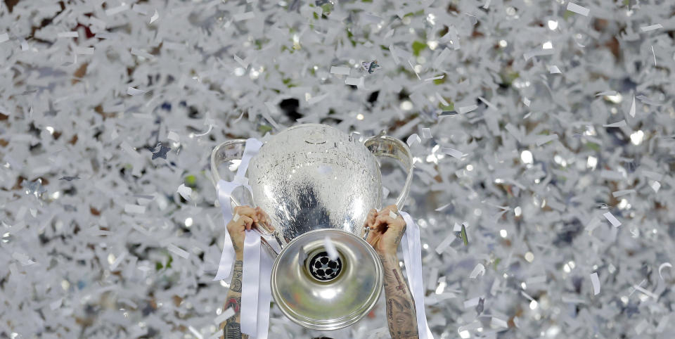 FILE - In this Saturday, May 28, 2016 file photo Real Madrid's Sergio Ramos celebrates with the trophy after the Champions League final soccer match between Real Madrid and Atletico Madrid at the San Siro stadium in Milan, Italy. In the absence of the Champions League final on Saturday, The Associated Press will take a look back at some of the greatest teams, players and matches in the history of the tournament. The AP will pick a topic for every letter of the alphabet to remember the greats of the game and the greatest games, going back to when the competition was called the European Cup and through its transformation into the Champions League. (AP Photo/Manu Fernandez, File)