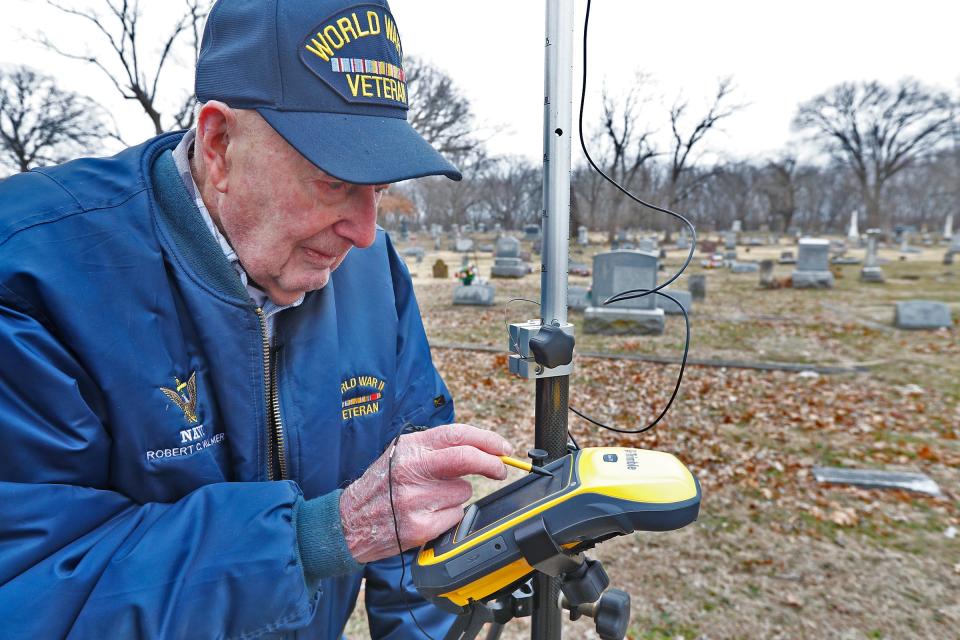 Bob Vollmer, 102, checks a GPS reading as he surveys in the Riverside Cemetery in Clinton, Indiana on Wednesday, Feb. 5.. It was his last day at work before retiring after working for the Department of Natural Resources for 57 years.