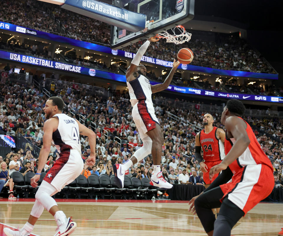 LAS VEGAS, NEVADA - JULY 10: LeBron James #6 of the United States dunks ahead of Dillon Brooks #24 and RJ Barrett #9 of Canada off of an alley-oop pass from Stephen Curry #4 in the second half of their exhibition game ahead of the Paris Olympic Games at T-Mobile Arena on July 10, 2024 in Las Vegas, Nevada. The United States defeated Canada 86-72. (Photo by Ethan Miller/Getty Images)