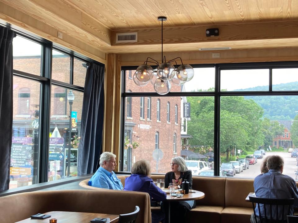Customers dine at Hen of the Wood in Waterbury on June 29, 2023. The brick building across the street houses the Prohibition Pig restaurant and brewery, which like Hen of the Wood is owned by Eric Warnstedt.