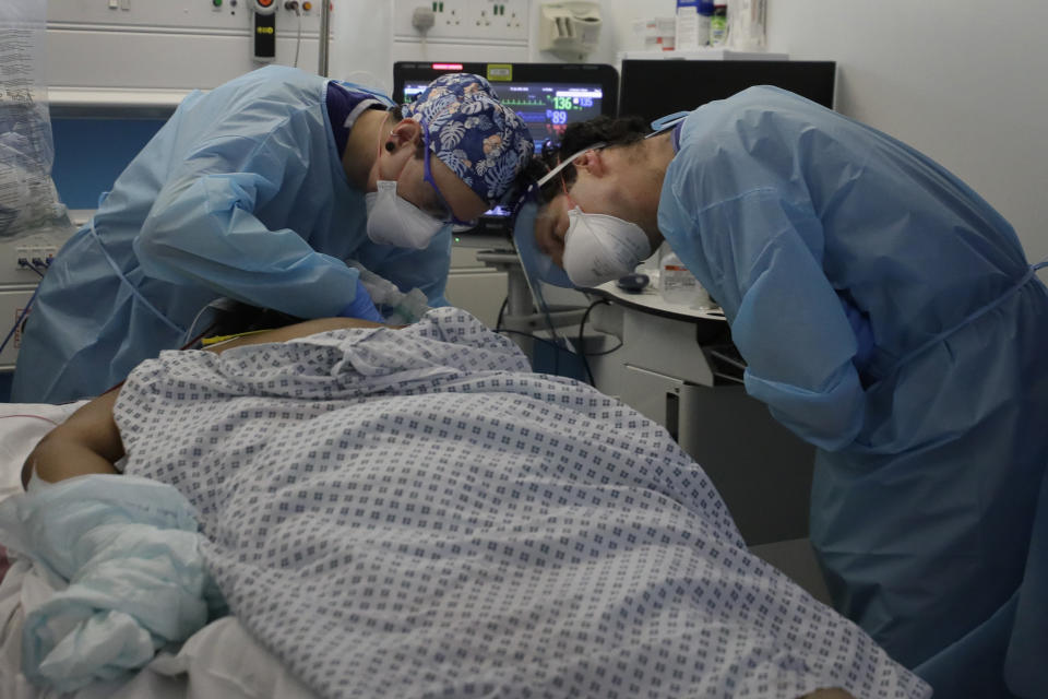 Critical Care staff look after a COVID-19 patient on the Christine Brown ward at King's College Hospital in London, Wednesday, Jan. 27, 2021. The scale of Britain's coronavirus outbreak can seem overwhelming, with tens of thousands of new infections and more than 1,000 deaths added each day. But on hospitals' COVID-19 wards, the pandemic feels both epic and intimate, as staff fight the virus one patient at a time, and with no end in sight. (AP Photo/Kirsty Wigglesworth, Pool)