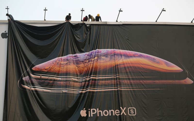 FILE PHOTO: Workers adjust a hoarding of the newly launched iPhone XS in Ahmedabad