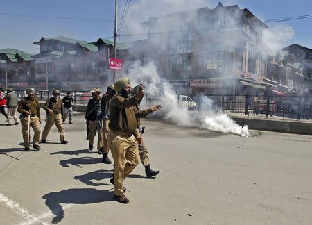 An Indian policeman gestures towards Kashmiri protesters during a demonstration against the plan to resettle Hindus, in Srinagar April 10, 2015. REUTERS/Danish Ismail