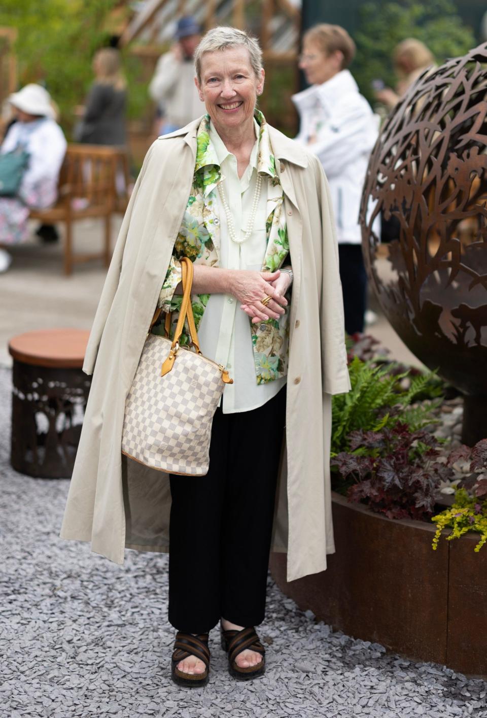 Lynn Leipzig, 60, wears a Dolce & Gabbana printed shirt with a J Crew trench coat, and pearl necklaces