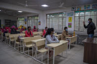 Students wearing face masks as a precaution against the coronavirus, attend classes as schools reopen after being closed for months due to the COVID-19 pandemic in New Delhi, India, Monday, Jan. 18, 2021. Delhi on Monday opened schools for students of grade 10 and 12 after a gap of more than nine months. (AP Photo/Altaf Qadri)