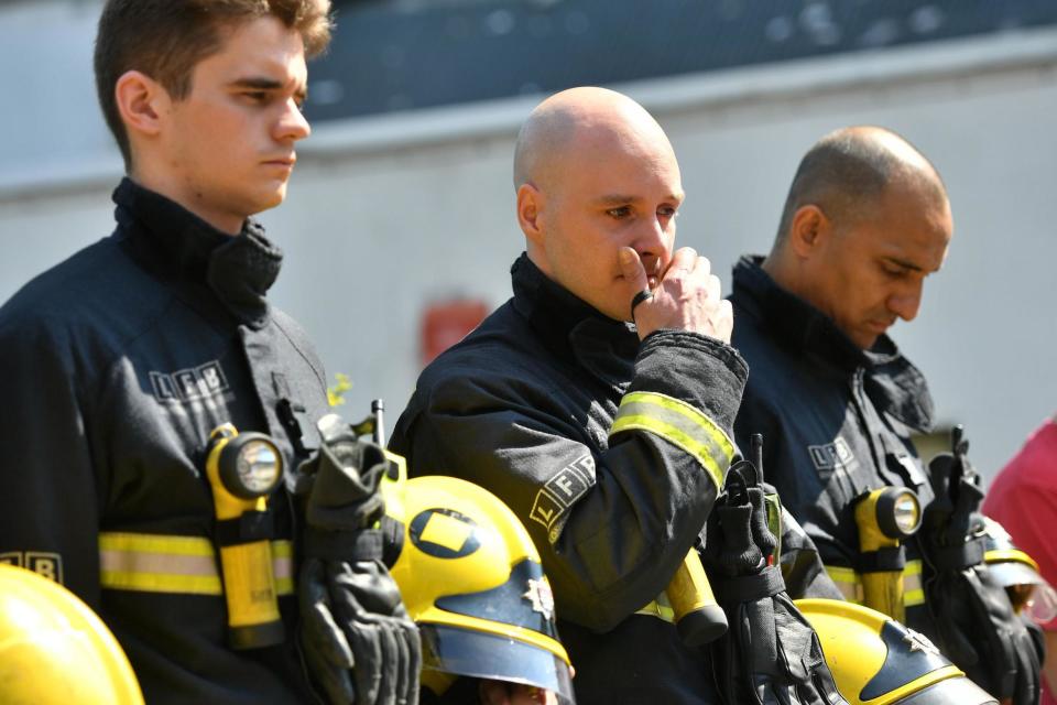 Fighfighters at Latymer Community Centre observe a minute's silence near to Grenfell Tower in west London: PA