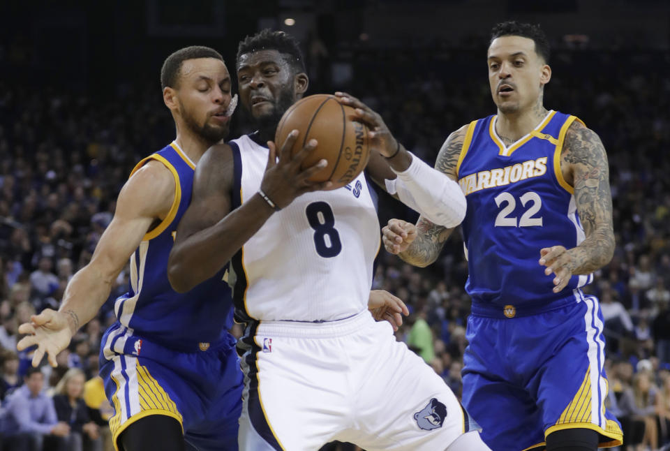 Memphis Grizzlies' James Ennis III (8) works under the basket as Golden State Warriors' Stephen Curry, left, and Matt Barnes (22) defend during the first half of an NBA basketball game Sunday, March 26, 2017, in Oakland, Calif. (AP Photo/Marcio Jose Sanchez)