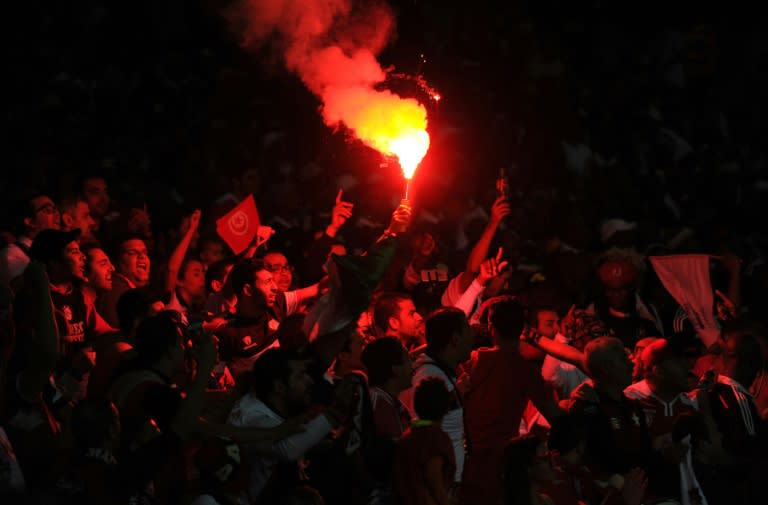 Etoile du Sahel's supporters light flares and cheer on their team after they scored during the first final of the 2015 CAF - Confederation of African Football Cup match against South Africa's Orlando Pirates on November 21, 2015 in Johannesburg