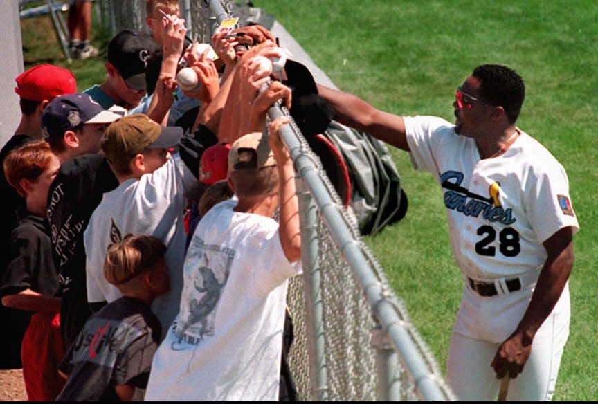 The Sioux Falls Canaries' Pedro Guerrero signs autographs for a group of young fans.