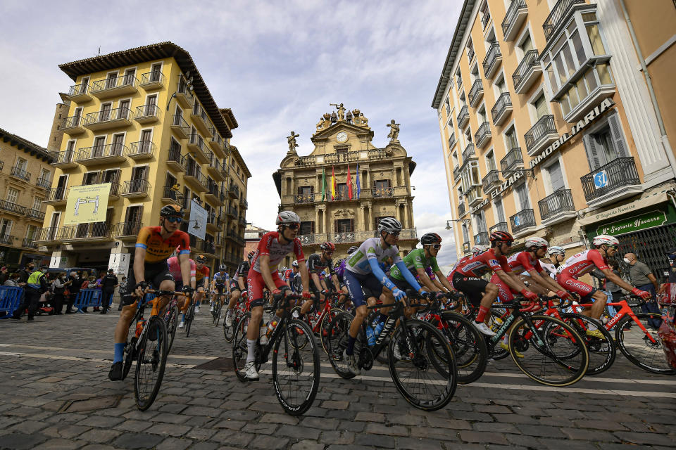 El pelotón pasa frente a la Plaza del Ayuntamiento durante la segunda etapa de la Vuelta a España, el miércoles 21 de octubre de 2020, entre Pamplona y Lekunberri. (AP Foto/Álvaro Barrientos)