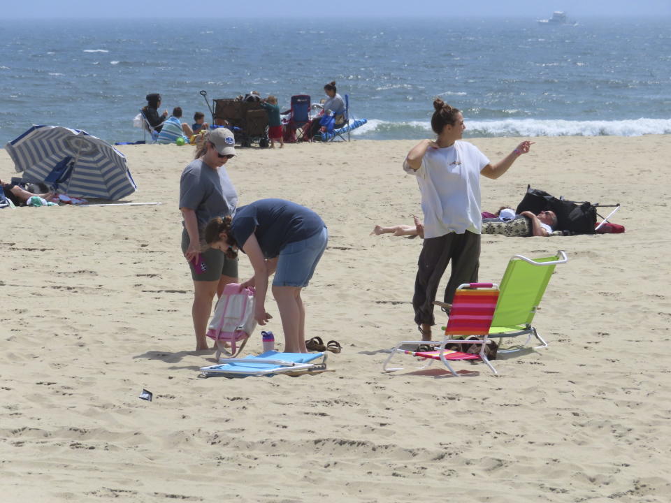 People sit on the beach on a weekday afternoon in Ocean Grove, N.J. on May 2, 2024. The state of New Jersey says the Ocean Grove Camp Meeting Association is violating state beach access laws by keeping people off the beach until noon on Sundays. (AP Photo/Wayne Parry)