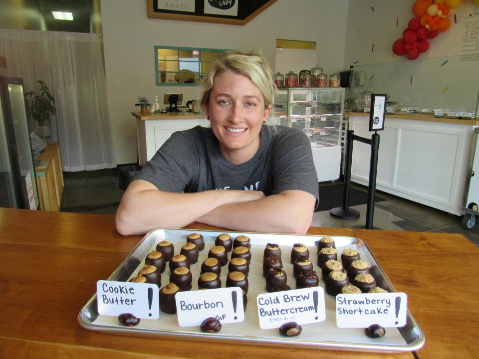 Alicia Hindman poses with a sampling of her stuffed buckeyes at The Buckeye Lady, her new store at 4493 N. High St. in Clintonville.