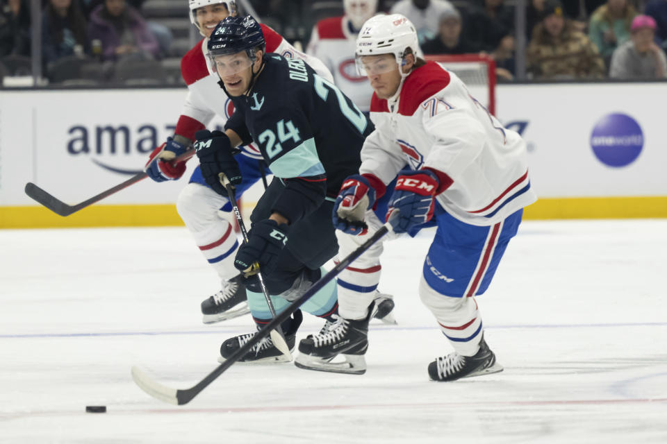 Seattle Kraken defenseman Jamie Oleksiak, left, and Montreal Canadiens forward Jake Evans battle for the puck during the first period of an NHL hockey game, Tuesday, Dec. 6, 2022, in Seattle. (AP Photo/Stephen Brashear)