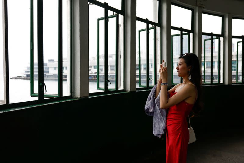 Laura Li, 28, takes photos, a day ahead of the Chinese Labour Day 'Golden Week' holidays, in Hong Kong