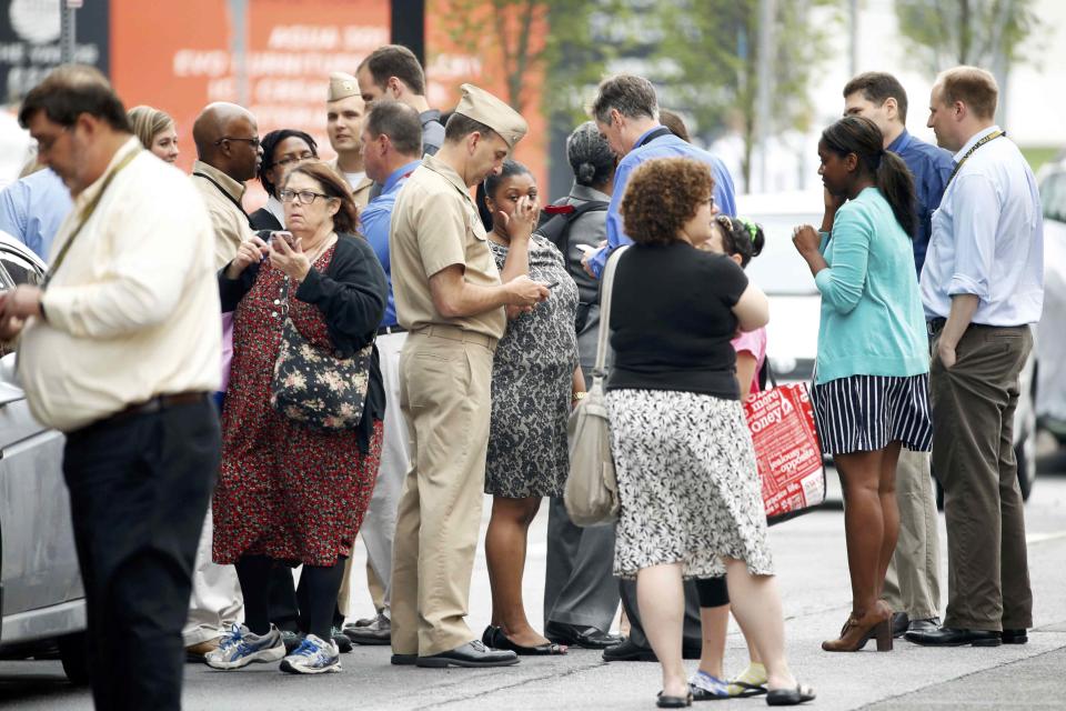 Bystanders look for more information as police respond to reports of a shooting and subsequent lockdown at the U.S. Navy Yard in Washington