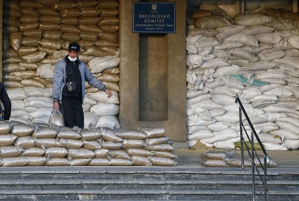 A pro-Russian protester strengthens barricades outside the mayor's office in Slaviansk