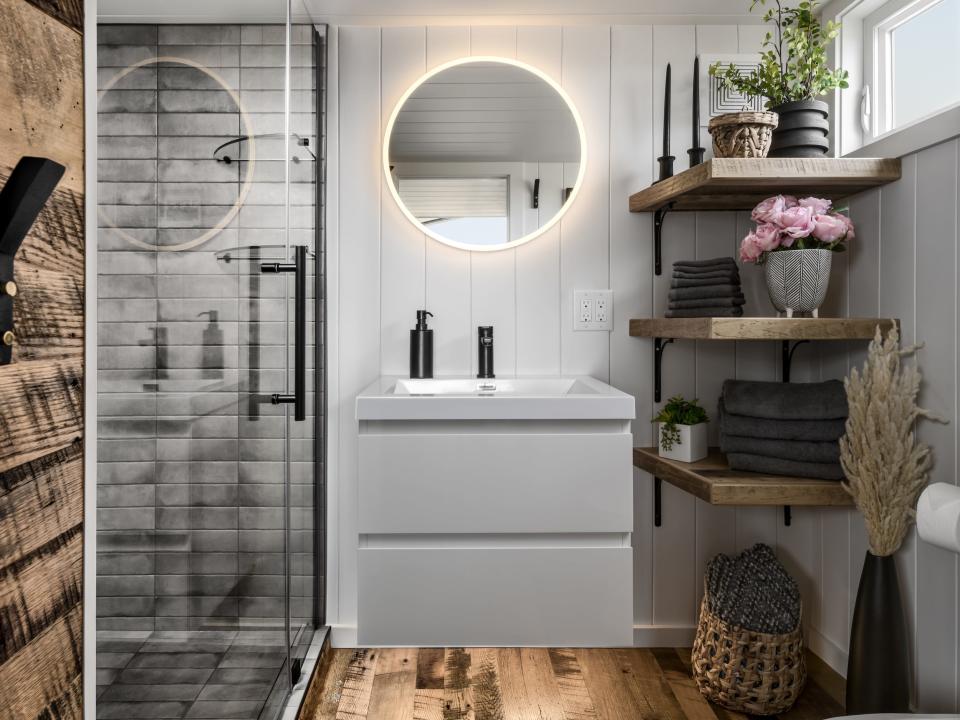 a bathroom with a vanity, shelves, shower, sink