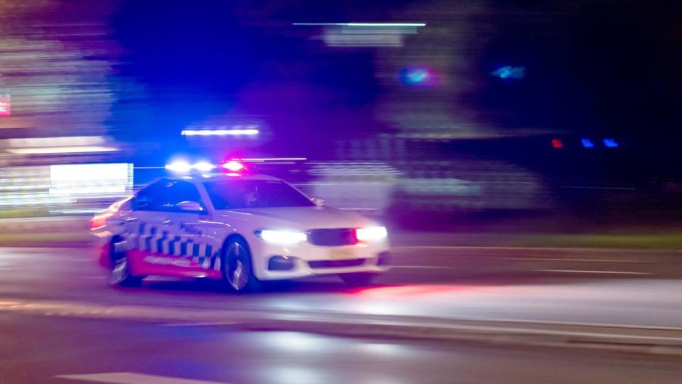 A police car races to the scene of an incident, Sydney