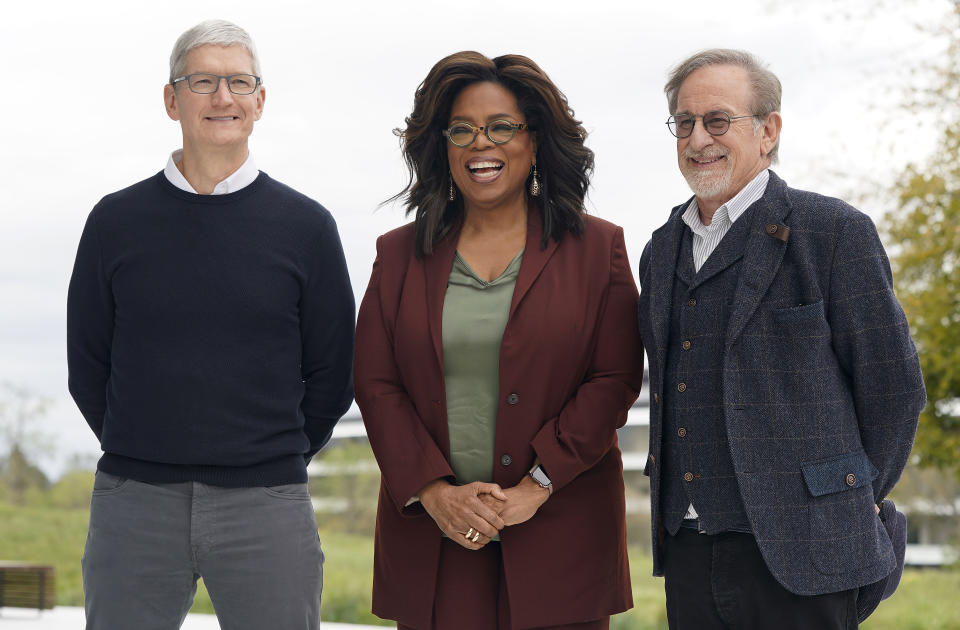 From left, Apple CEO Tim Cook, Oprah Winfrey and Steven Spielberg pose for a photo outside the Steve Jobs Theater during an event to announce new Apple products Monday, March 25, 2019, in Cupertino, Calif. (AP Photo/Tony Avelar)