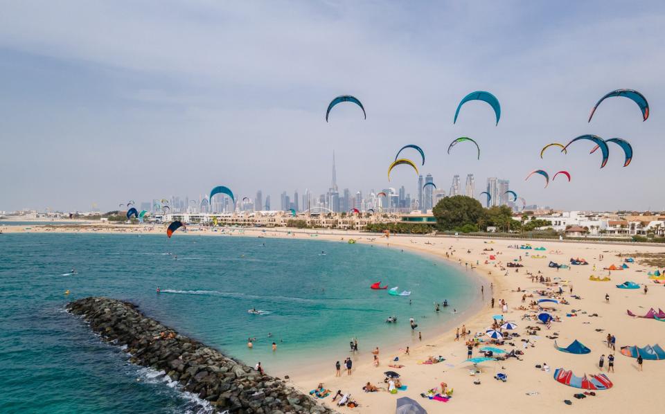 An aerial photo of Kite Beach in Dubai, filled with kite surfers and their colourful kites flying through the air