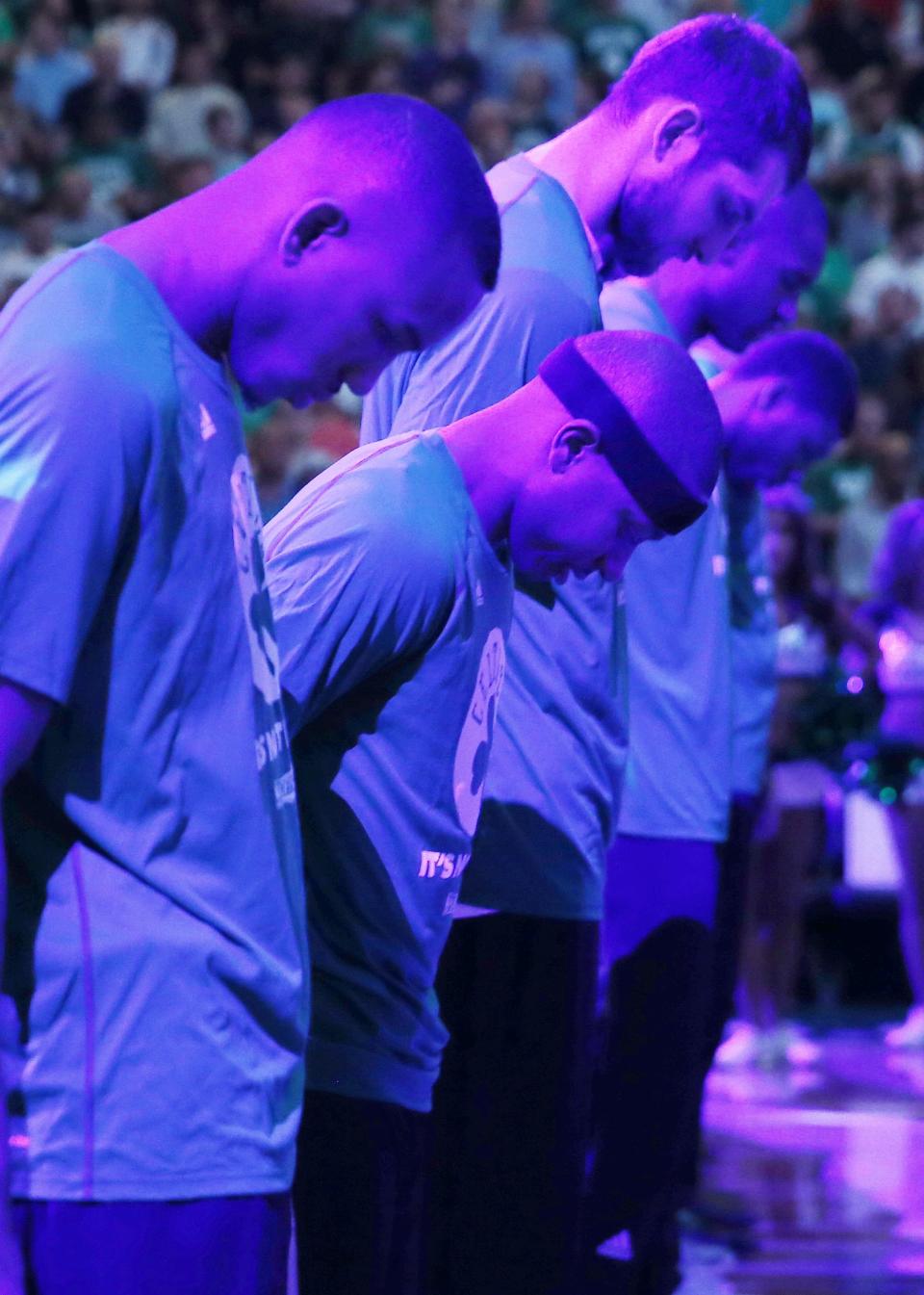 Boston Celtics' Isaiah Thomas, center, and teammates bow their heads during a moment of silence for Thomas' sister Chyna before a first-round NBA playoff basketball game against the Chicago Bulls Sunday, April 16, 2017, in Boston. (AP Photo/Michael Dwyer)