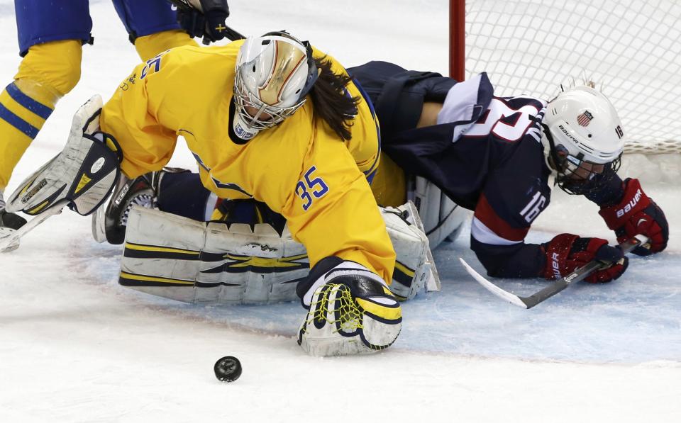 Team USA's Kelli Stack (R) collides with Sweden's goalie Valentina Wallner during the first period of their women's semi-final ice hockey game at the 2014 Sochi Winter Olympics, February 17, 2014. REUTERS/Grigory Dukor (RUSSIA - Tags: OLYMPICS SPORT ICE HOCKEY)