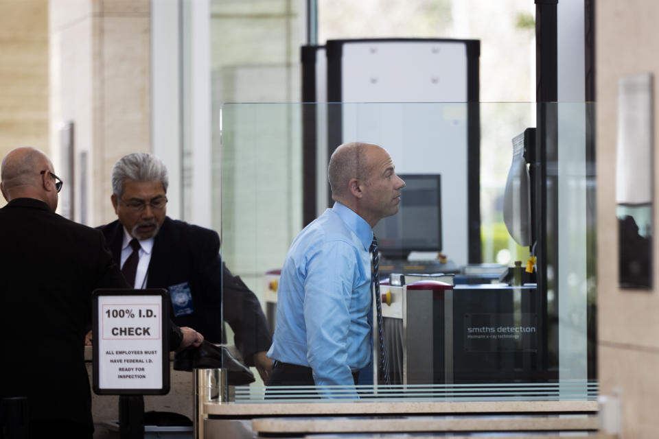 Attorney Michael Avenatti, center, walks through a metal detector at federal court Monday, April 1, 2019, in Santa Ana, Calif. Avenatti appeared in federal court on charges he fraudulently obtained $4 million in bank loans and pocketed $1.6 million that belonged to a client. (AP Photo/Jae C. Hong)