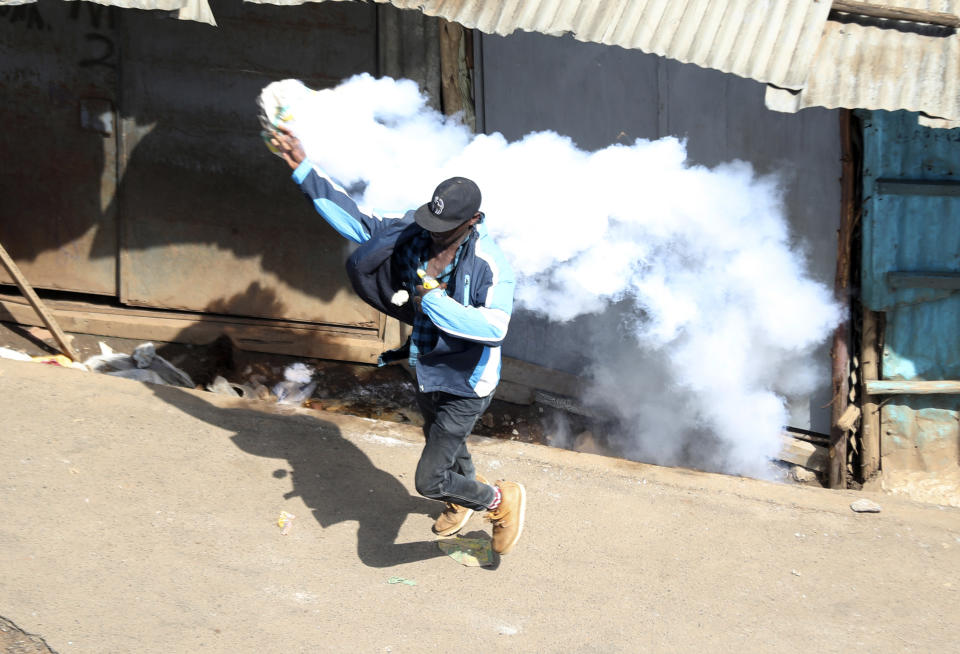 A protester caught in tear-gas during a mass rally called by the opposition leader Raila Odinga over the high cost of living in Kibera Slums, Nairobi Monday, March 27, 2023. Police in Kenya are on high alert ahead of the second round of anti-government protests organized by the opposition that has been termed as illegal by the government. Police chief Japheth Koome insists that Monday's protests are illegal but the opposition leader Raila Odinga says Kenyans have a right to demonstrate.(AP Photo/Brian Inganga)