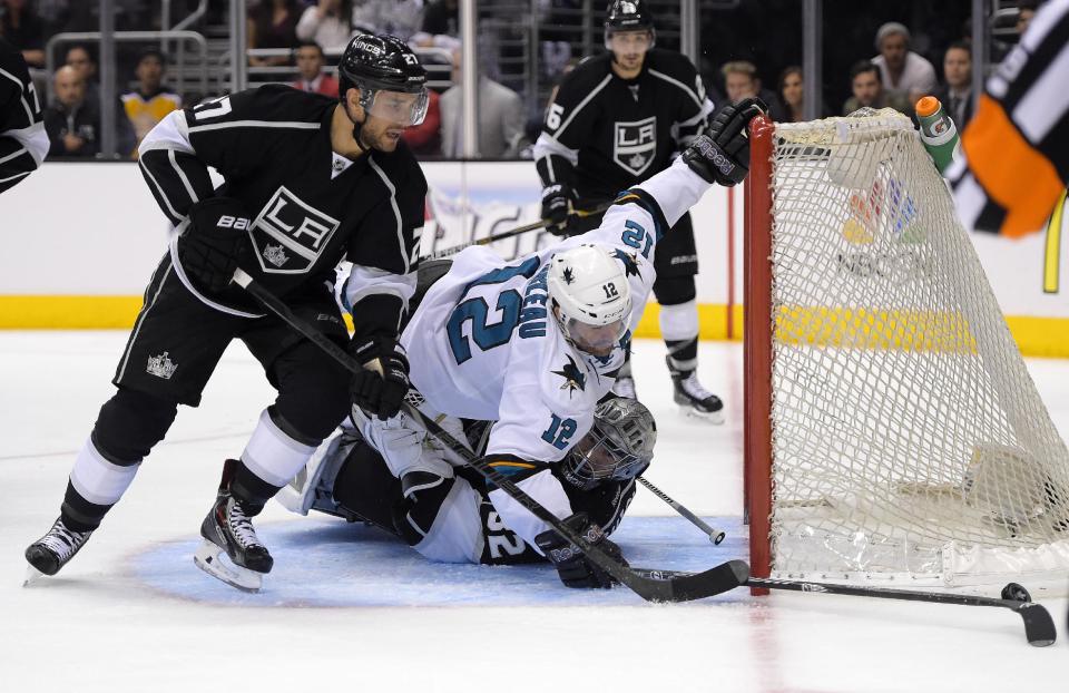 San Jose Sharks center Patrick Marleau, center, falls over Los Angeles Kings goalie Jonathan Quick, lower right, as defensemen Alec Martinez, left, and Slava Voynov, of Russia, watch during the third period in Game 6 of an NHL hockey first-round playoff series, Monday, April 28, 2014, in Los Angeles. The Kings won 4-1. (AP Photo)