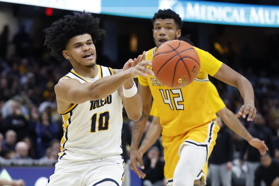 Toledo guard RayJ Dennis (10) passes the ball against Kent State center Cli'Ron Hornbeak (42) during the second half of an NCAA college basketball game for the championship of the Mid-American Conference Tournament, Saturday, March 11, 2023, in Cleveland. (AP Photo/Ron Schwane)