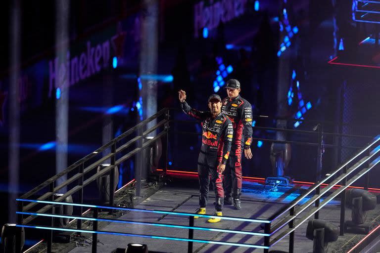 El neerlandés Max Verstappen y su compañero, el mexicano Sergio Checo Pérez saludan durante la ceremonia de apertura de las actividades del Gran Premio de Las Vegas.