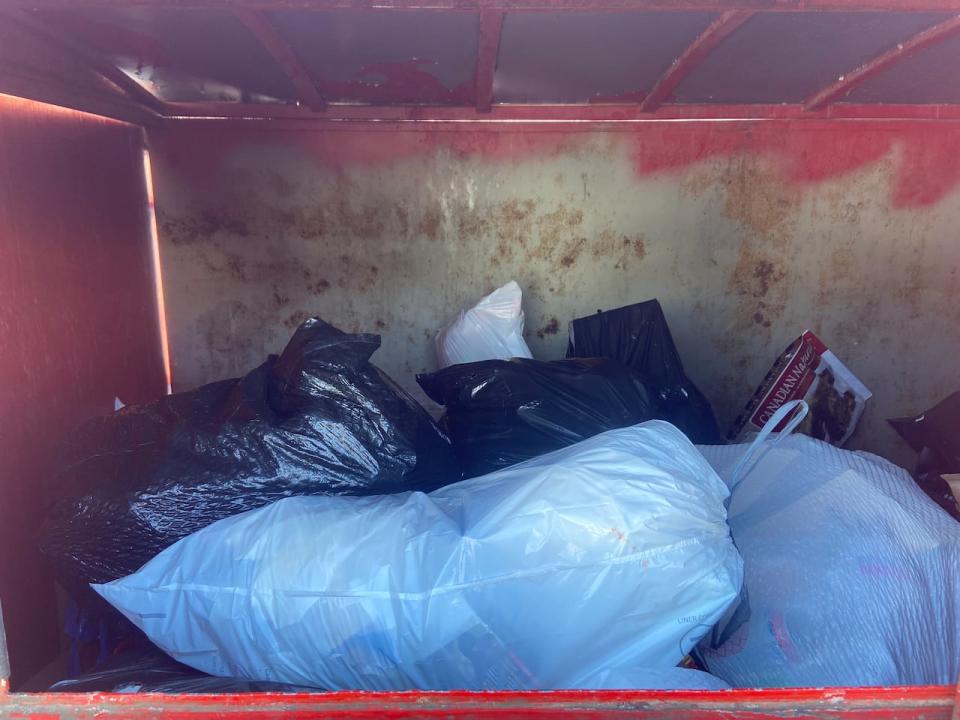 Household trash, and cardboard thrown in one of the city's rented garbage bins.