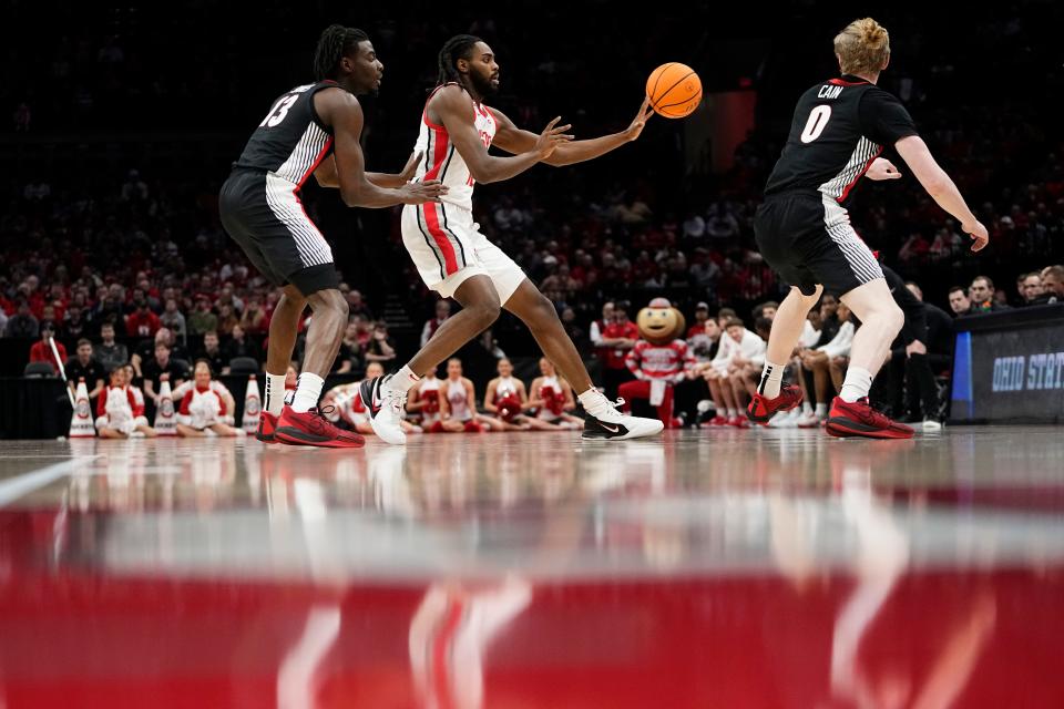 Ohio State guard Evan Mahaffey passes between Georgia players Dylan James (13) and Blue Cain (0).