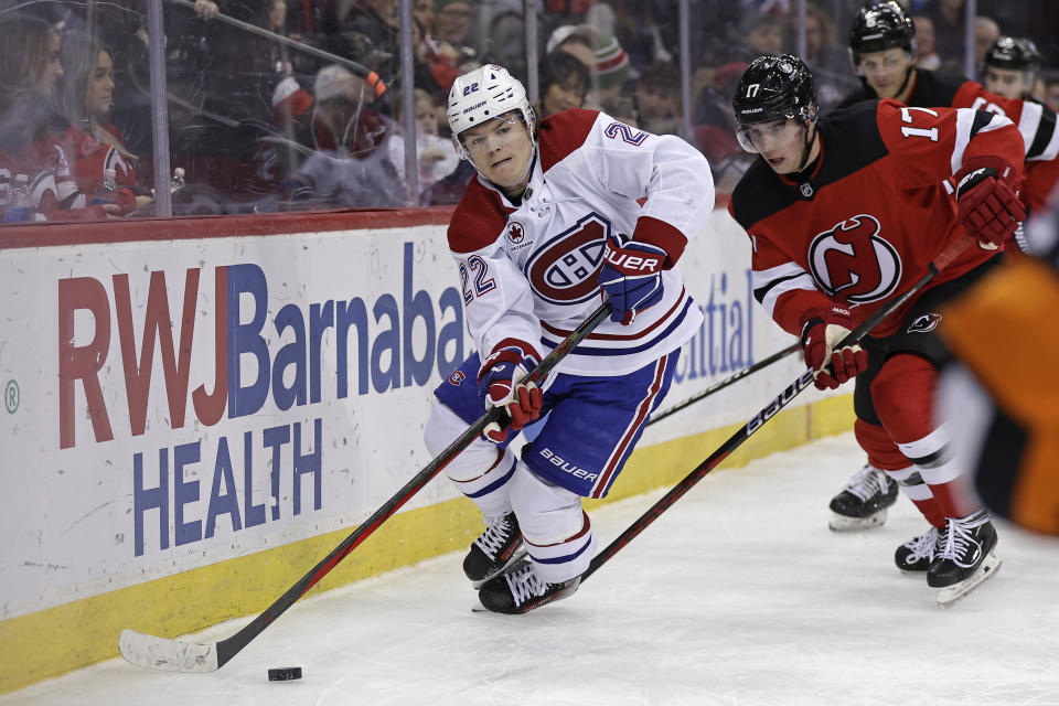 Montreal Canadiens right wing Cole Caufield (22) controls the puck past New Jersey Devils defenseman Simon Nemec during the third period of an NHL hockey game Wednesday, Jan. 17, 2024, in Newark, N.J. The Canadiens won 3-2. (AP Photo/Adam Hunger)