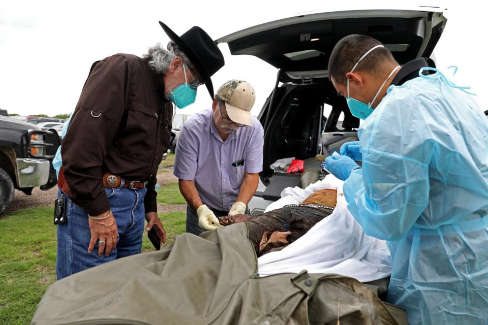 Three men surround a body.