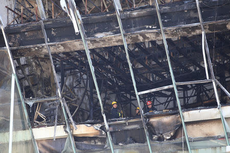 Firefighters inspect the site where a fire broke out at the Shanghai Hongkou soccer stadium in Shanghai, China March 28, 2017. REUTERS/Aly Song