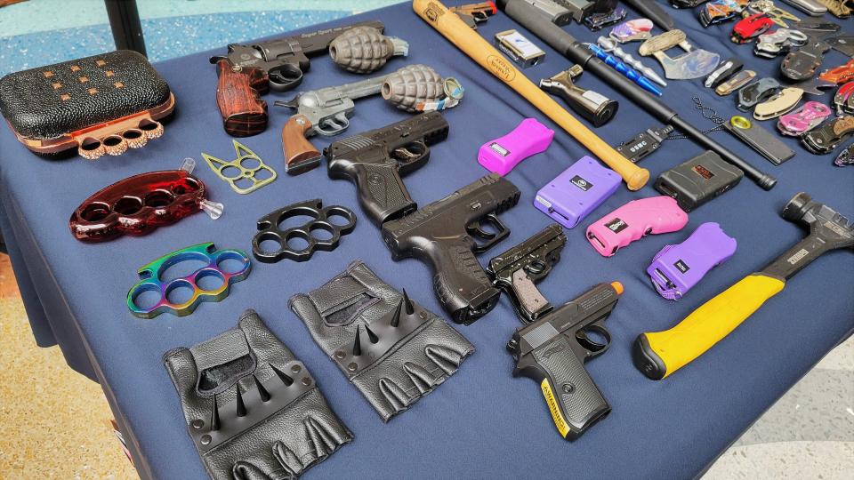 Here are just some of the prohibited items confiscated in recent weeks from arriving passengers during TSA security checks, including brass knuckles (left), BB and pellet guns, empty grenades and Tasers (center), a hammer, torches, a small baseball bat and knives.