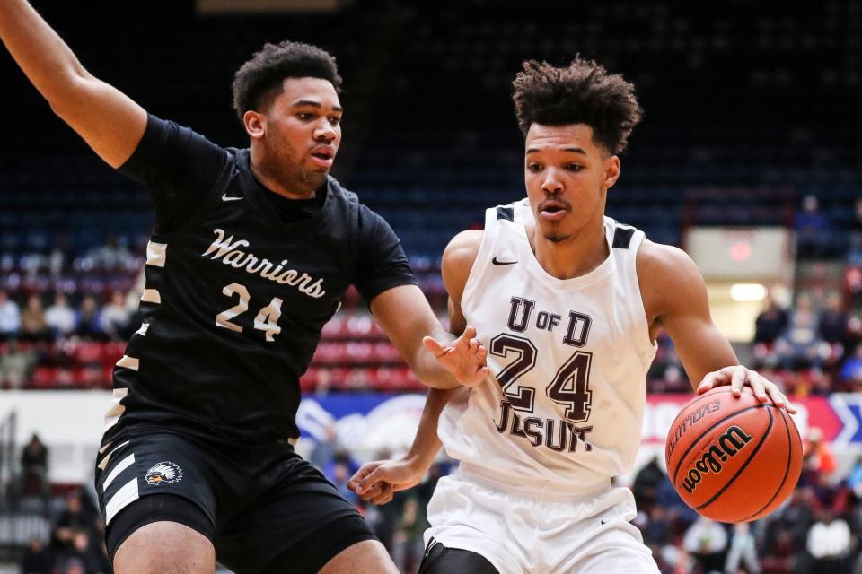 U-D Jesuit's Zavier Banks (24) dribbles against Birmingham Brother Rice forward Xavier Thomas (24) during the first half of the Bishop division of CHSL championship game at Calihan Hall in Detroit on Friday, Feb. 24, 2023.