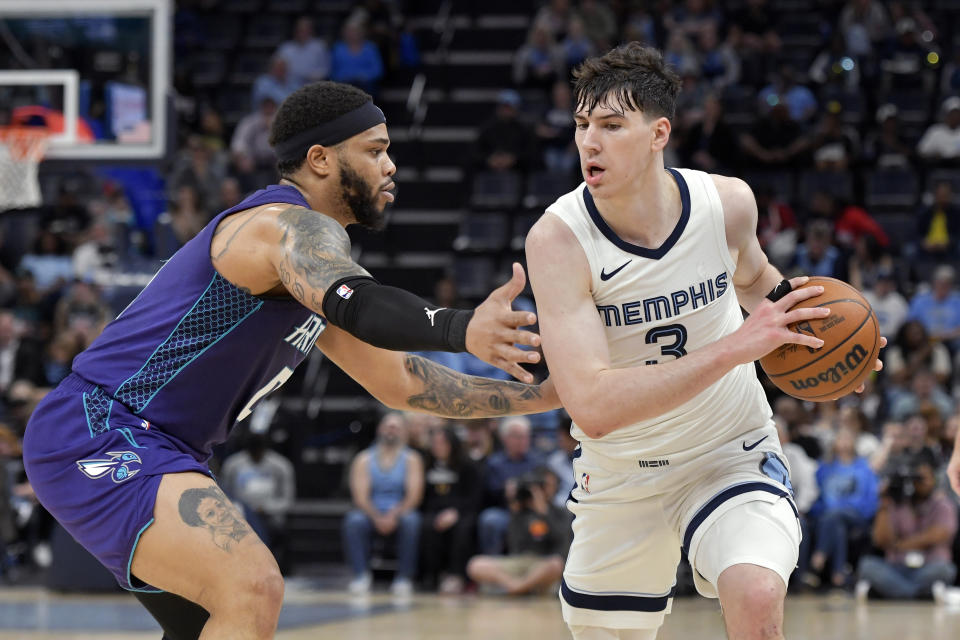 Memphis Grizzlies forward Jake LaRavia (3) is defended by Charlotte Hornets forward Miles Bridges (0) during the first half of an NBA basketball game Wednesday, March 13, 2024, in Memphis, Tenn. (AP Photo/Brandon Dill)