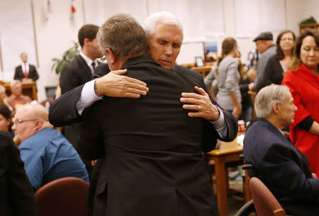 U.S. Vice President Mike Pence hugs a man at Floresville high school during a visit with family and victims of the shooting at First Baptist Church in Sutherland Springs, before a vigil in Floresville, Texas, U.S., November 8, 2017. REUTERS/Jonathan Bachman