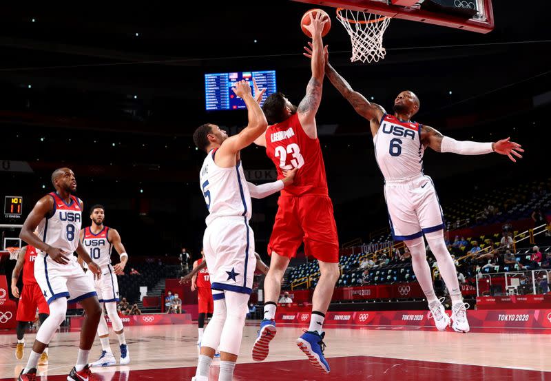 Foto del miércoles del iraní Aaron Geramipoor en acción ante los estadounidenses Damian Lillard y Zach Lavine