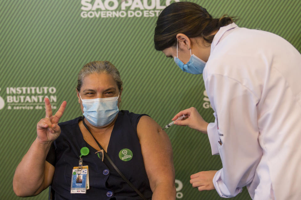 A woman celebrates as she gets her shot of the COVID-19 vaccine produced by China’s Sinovac Biotech Ltd, at the Hospital das Clinicas in Sao Paulo, Brazil, Sunday, Jan. 17, 2021. (AP Photo/Carla Carniel)