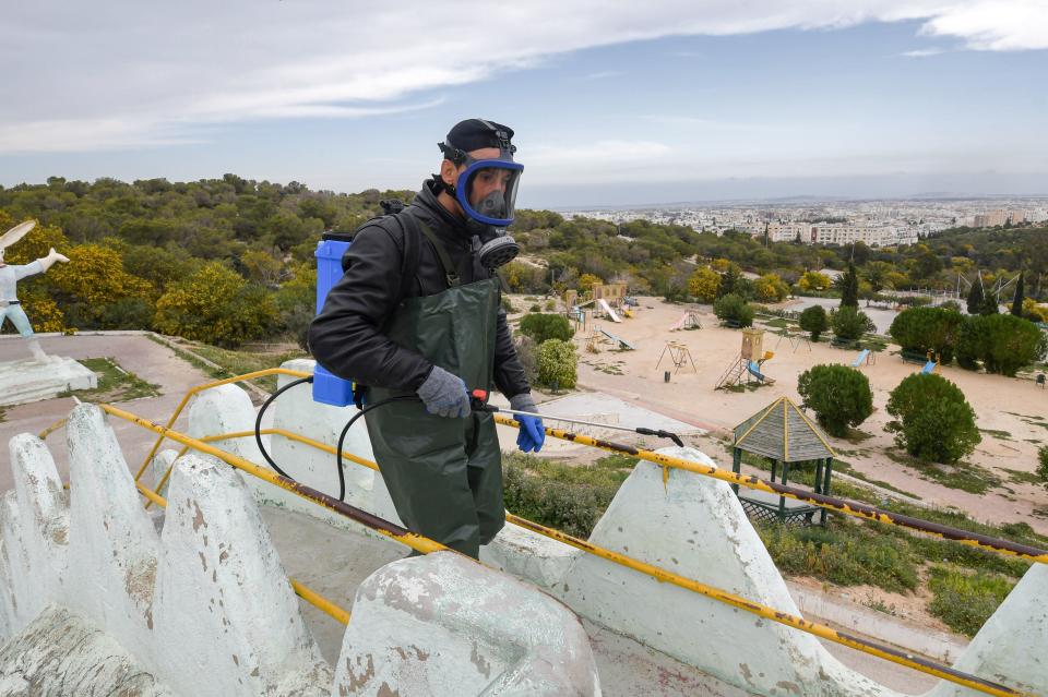 A health worker disinfects the Enahli amusement park on March 16, 2020 at Ariana near Tunis, which has been closed to the public from today during the coronavirus COVID-19 pandemic. - A decision was made today by the authorities to ban parties, parks, weekly souks and all sporting activities. (Photo by FETHI BELAID / AFP) (Photo by FETHI BELAID/AFP via Getty Images)